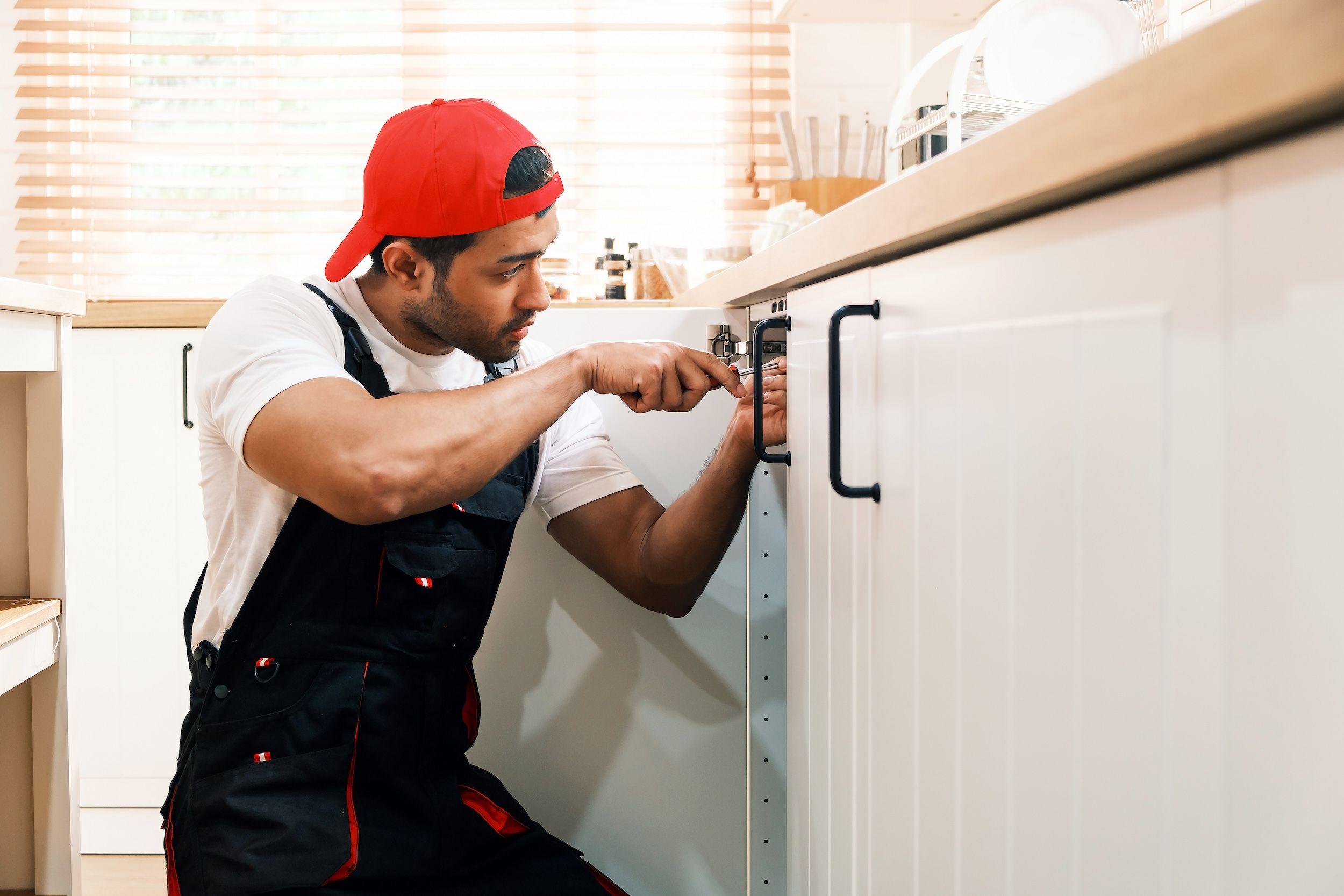 Monteur richtet Schranktür in Einbauküche von Küchen Wik in Füssen aus.