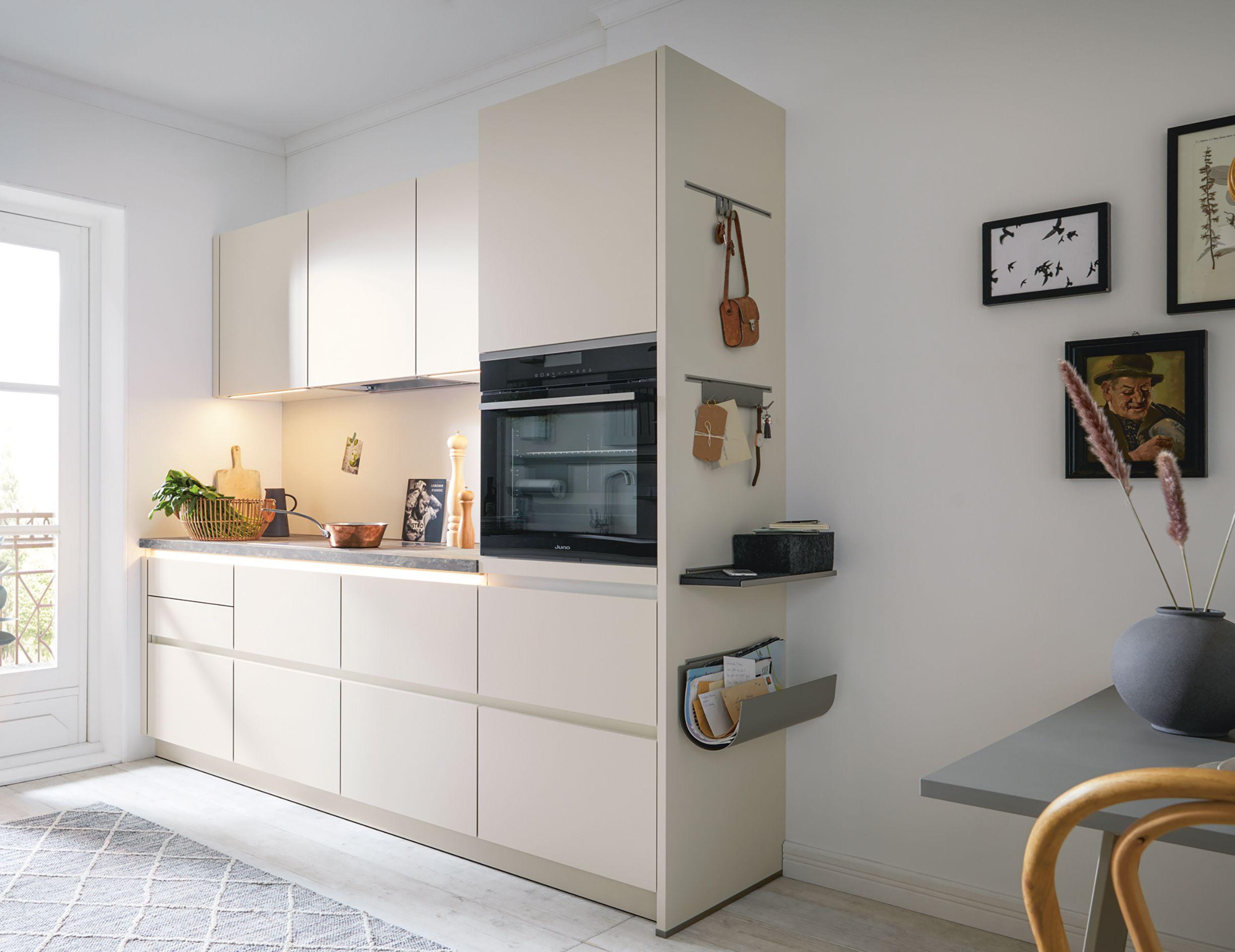 Kompakte grifflose Küche in hellem Design mit integriertem Backofen und praktischen Organisationslösungen – modernes Küchenstudio in Füssen für clevere Planung auf kleinem Raum.