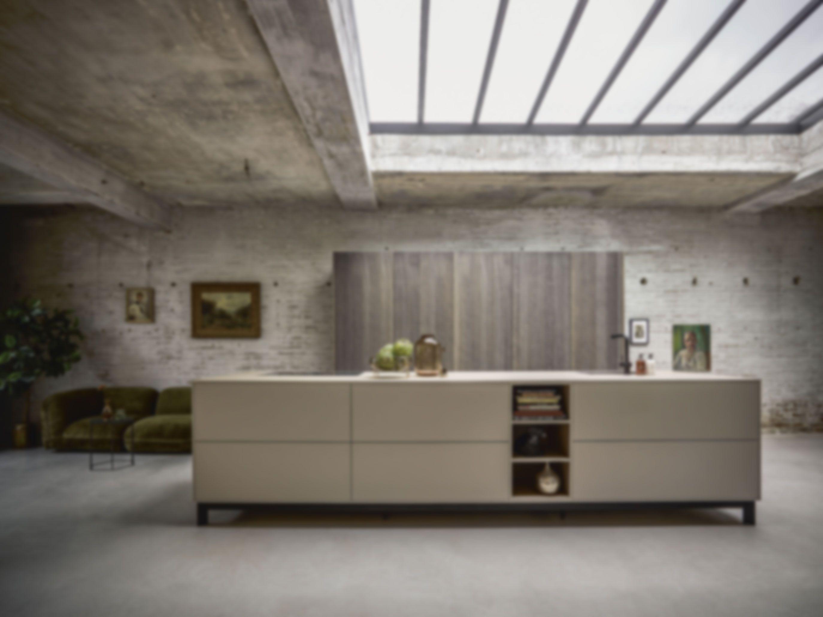 Große moderne Kochinsel in loftartiger Küche mit Betonoptik, offenen Regalen und zurückhaltendem Design – stilvolle Küchenplanung im Allgäu für großzügige Räume.