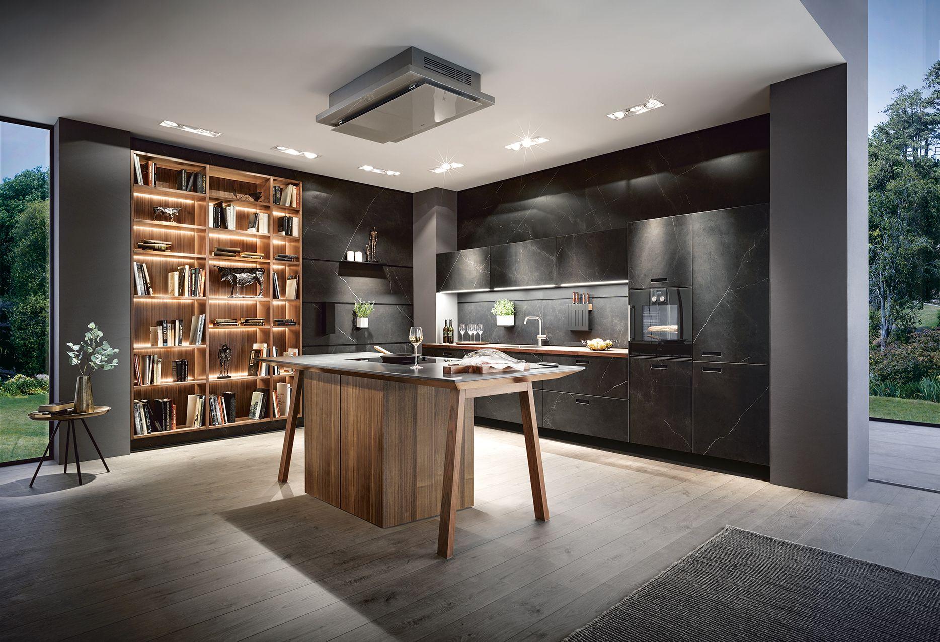 Große moderne Kochinsel in loftartiger Küche mit Betonoptik, offenen Regalen und zurückhaltendem Design – stilvolle Küchenplanung im Allgäu für großzügige Räume.